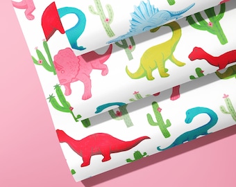 May include: A sheet of white wrapping paper with a repeating pattern of colourful dinosaurs and cacti. The dinosaurs are pink, red, blue, and green. The cacti are green with pink flowers.