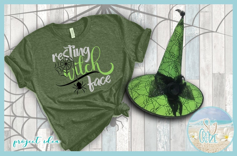 May include: Green t-shirt with the text "resting witch face" in black and green lettering. A green witch hat with black spiderweb design is next to the shirt.