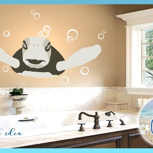 May include: A bathroom with a bathtub and a window. A turtle with white bubbles is on the wall. The text "project idea" is on the counter below the bathtub. A round sticker with the text "Sig Craze" is on the wall next to the window.