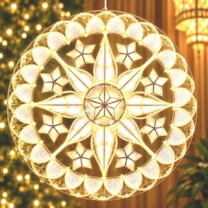May include: A circular, gold-toned metal frame ornament featuring an intricate geometric design. The structure includes a central star, radiating petal-like shapes, and smaller stars, all illuminated by warm white LED lights throughout the frame.