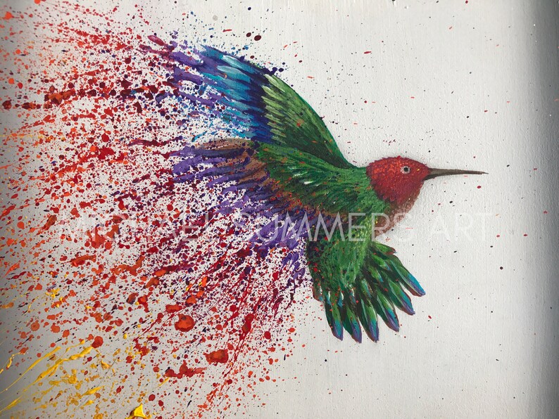 May include: A painting of a hummingbird in flight with a colorful splatter background. The hummingbird is green, red, and blue with its wings spread out. The background is a white canvas with red, orange, yellow, and purple paint splatters.