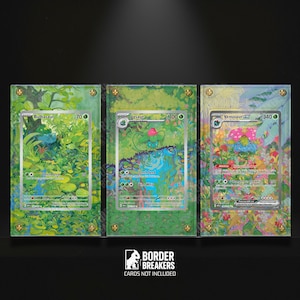 May include: Three framed Pokémon cards featuring Bulbasaur, Ivysaur, and Venusaur. Each card is displayed within a clear acrylic frame, set against a vibrant, green, floral-themed background. The frames are secured with gold-coloured screws, and the text "BORDER BREAKERS" is visible.