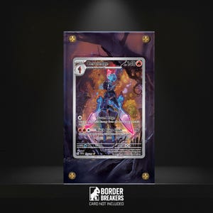May include: A framed Ceruledge Pokémon card. The card features a character with blue and pink accents. The frame is dark with gold-colored screws. The text "BORDER BREAKERS CARD NOT INCLUDED" is at the bottom.