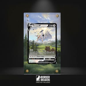 May include: A framed Pokémon trading card featuring Arceus V, set against a mountain and forest backdrop. The card is encased in clear acrylic with gold-toned corner fixings. The text "BORDER BREAKERS" and "CARD NOT INCLUDED" are visible.