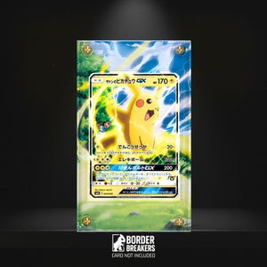 Könnte beinhalten: Eine gerahmte Pokémon-Sammelkarte mit Pikachu und japanischem Text. Die Karte ist gelb mit Blitzeffekten und hat 170 HP. Der Rahmen ist transparent mit goldfarbenen Eckakzenten. Das Border Breakers-Logo befindet sich unten.