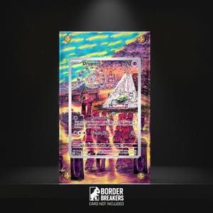 May include: A framed Drowzee Pokémon card with a colorful illustration of a carnival scene. The card is encased in a clear acrylic holder, secured with gold-colored screws. The Border Breakers logo is visible at the bottom.