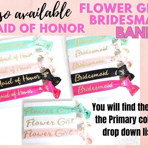 May include: Assortment of colorful elastic hair ties with gold lettering. The hair ties say "Maid of Honor", "Bridesmaid", and "Flower Girl".