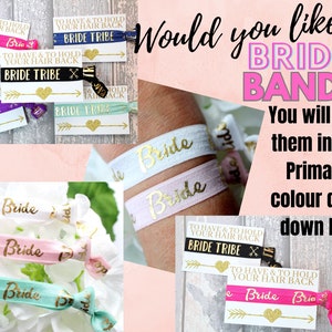 May include: Assortment of colorful hair ties with gold glitter lettering that reads "Bride". The hair ties are displayed on a white background with a card that reads "To have & to hold your hair back Bride Tribe".