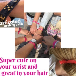 K&ouml;nnte beinhalten: Bilder mit elastischen Stretchb&auml;ndern. Eines zeigt ein schwarzes Band mit goldenem Text und einem Pfeildesign. Andere Bilder zeigen rosa B&auml;nder, die an Handgelenken und im Haar getragen werden. Der Text im Bild lautet: "Super s&uuml;&szlig; am Handgelenk und sieht toll in Ihren Haaren aus."