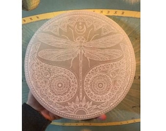 May include: A white selenite charging plate with a detailed mandala design featuring a dragonfly and the text "FIG. 1. DAY AND NIGHT".