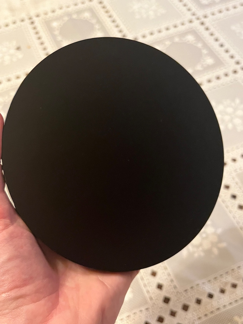 Peut inclure: Un dessous de verre rond noir en mat&eacute;riau lisse.