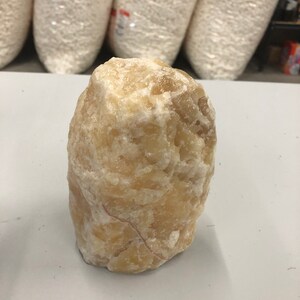 6” raw orange Calcite lamps with smooth base, with a circular opening at the bottom comes with cord and bulb