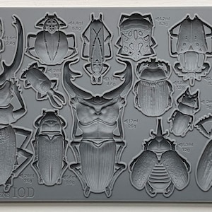 May include: A grey silicone mould with 12 different beetle shapes. The mould is labelled "SPECIMENS IOD" and includes measurements in millilitres and grams for each beetle.