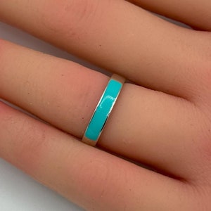 Op de afbeelding: Een dunne gouden ring met een turquoise inleg.