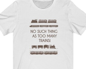 May include: White t-shirt with a brown graphic of different types of trains. The text on the shirt reads "NO SUCH THING AS TOO MANY TRAINS!"