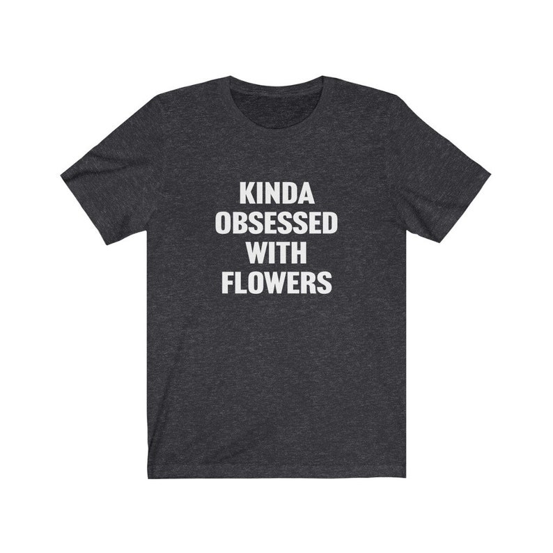 Puede incluir: Una camiseta gris oscuro jaspeada con el texto "Kinda obsessed with flowers" impreso en blanco.