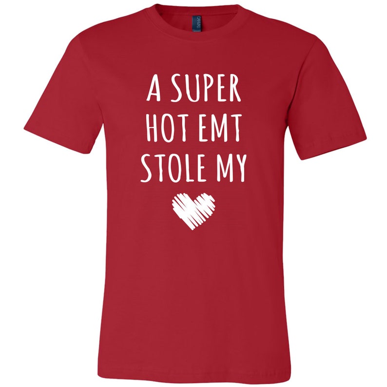 May include: Red t-shirt with white text that reads "A super hot EMT stole my" with a white heart drawn below the text.