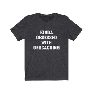 May include: A dark heather grey t-shirt with the text "Kinda obsessed with geocaching" printed in white.
