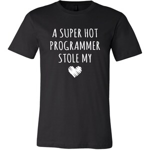 Pu&ograve; includere: Una maglietta nera con testo bianco che recita "Un programmatore super sexy mi ha rubato il cuore".