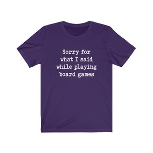 May include: Purple short-sleeved t-shirt with white text that reads "Sorry for what I said while playing board games".