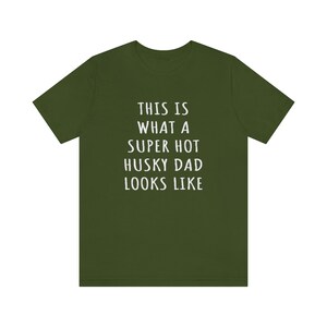 May include: A green t-shirt with white text that reads "This is what a super hot husky dad looks like."