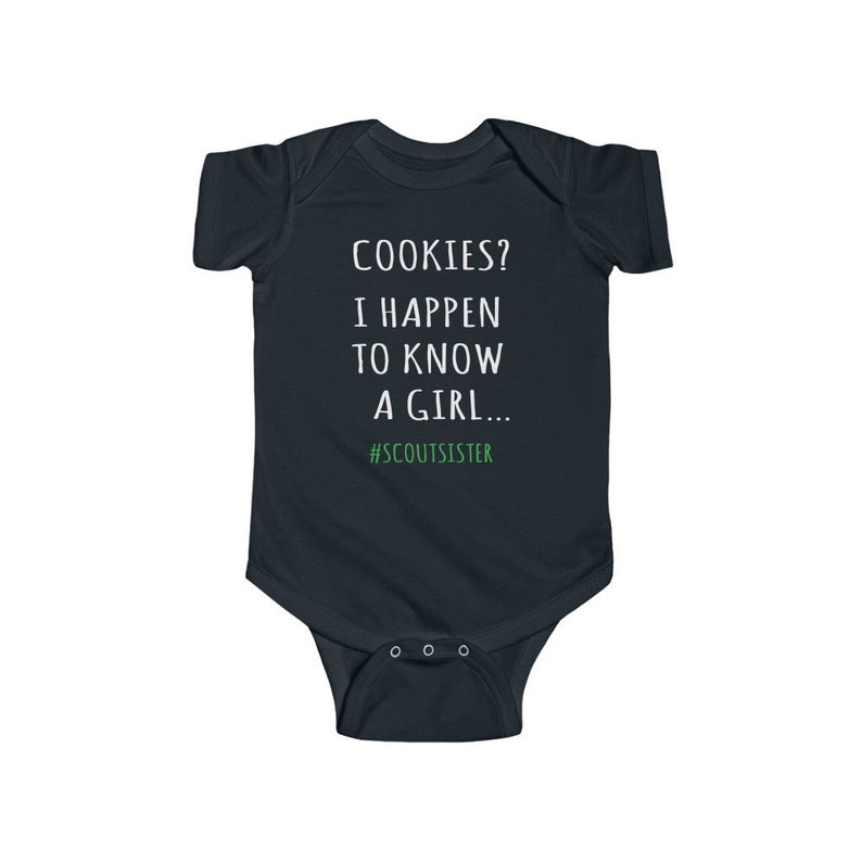 May include: A dark blue baby onesie with white text that reads "COOKIES? I HAPPEN TO KNOW A GIRL... #SCOUTSISTER".