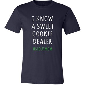 May include: Navy blue t-shirt with white text that reads "I know a sweet cookie dealer #scoutmom".