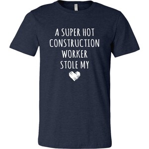 May include: A navy blue t-shirt with white text that reads "A super hot construction worker stole my heart".
