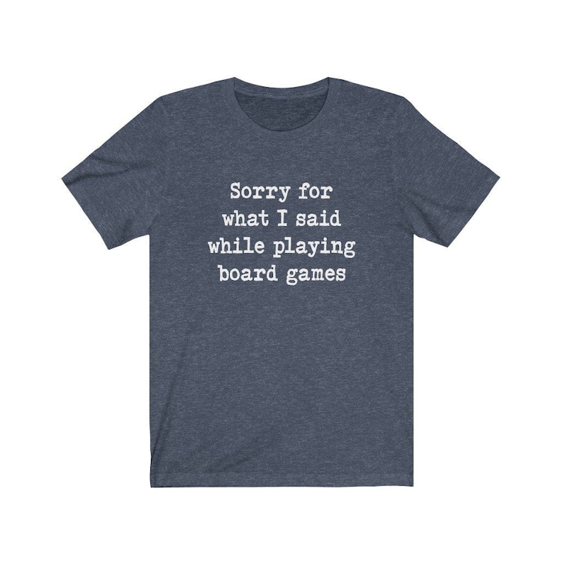 May include: A dark blue t-shirt with the text "Sorry for what I said while playing board games" in white.