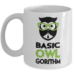 May include: White ceramic coffee mug with a black and green owl wearing glasses and a tie. The text "BASIC OWL GORITHM" is printed below the owl.
