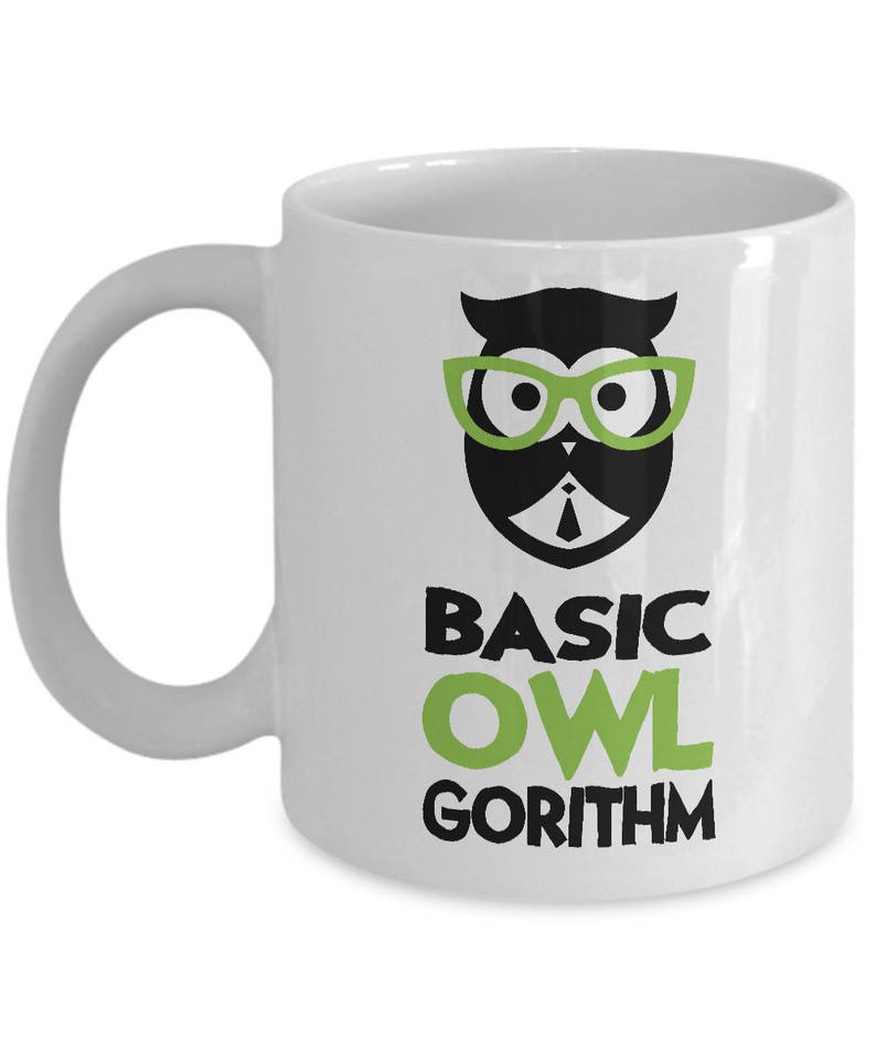 Puede incluir: Taza de caf&eacute; de cer&aacute;mica blanca con un b&uacute;ho negro y verde que lleva gafas y corbata. El texto "BASIC OWL GORITHM" est&aacute; impreso debajo del b&uacute;ho.