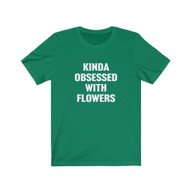 Puede incluir: Una camiseta verde con el texto "Kinda obsessed with flowers" en blanco.