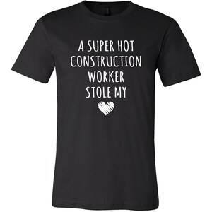 May include: Black t-shirt with white text that reads "A super hot construction worker stole my heart".