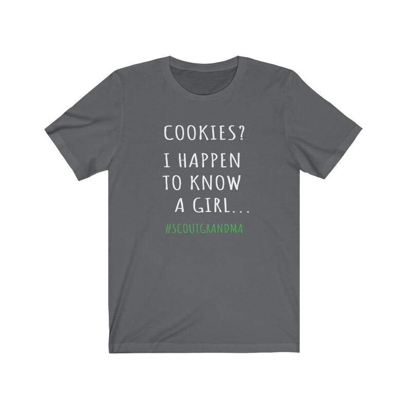Puede incluir: Camiseta gris oscuro con texto blanco que dice "COOKIES? I HAPPEN TO KNOW A GIRL... #SCOUTGRANDMA".