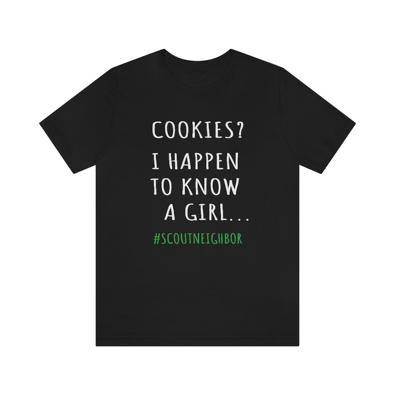 May include: Black t-shirt with white text that reads "COOKIES? I HAPPEN TO KNOW A GIRL... #SCOUTNEIGHBOR"