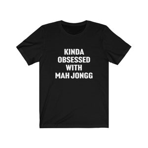 May include: Black t-shirt with white text that reads "Kinda obsessed with Mah Jongg".