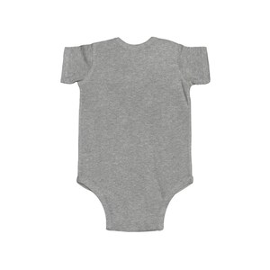 May include: A gray short-sleeved baby onesie with a snap closure.