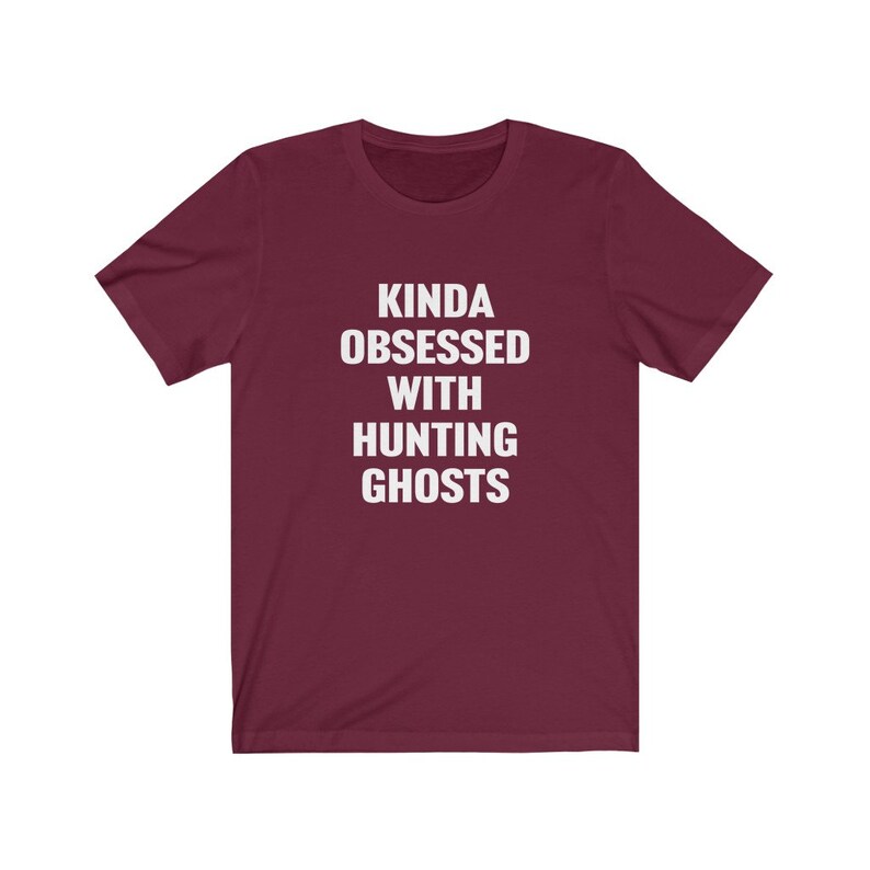 May include: Burgundy t-shirt with white text that reads "Kinda obsessed with hunting ghosts."