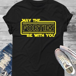 May include: Black t-shirt with a yellow graphic that says "May the Forties Be With You".