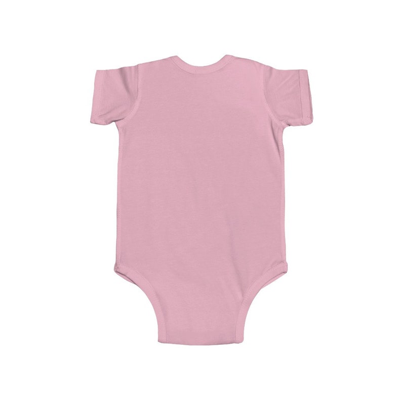 May include: A plain pink baby onesie with short sleeves.