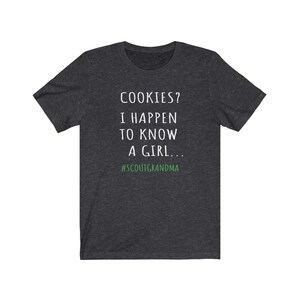 Puede incluir: Camiseta gris oscuro jaspeada con texto blanco que dice "COOKIES? I HAPPEN TO KNOW A GIRL... #SCOUTGRANDMA".