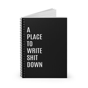 May include: A black spiral bound notebook with the text "A PLACE TO WRITE SHIT DOWN" in white.