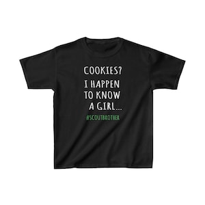 May include: Black t-shirt with white text that reads "COOKIES? I HAPPEN TO KNOW A GIRL... #SCOUTBROTHER".