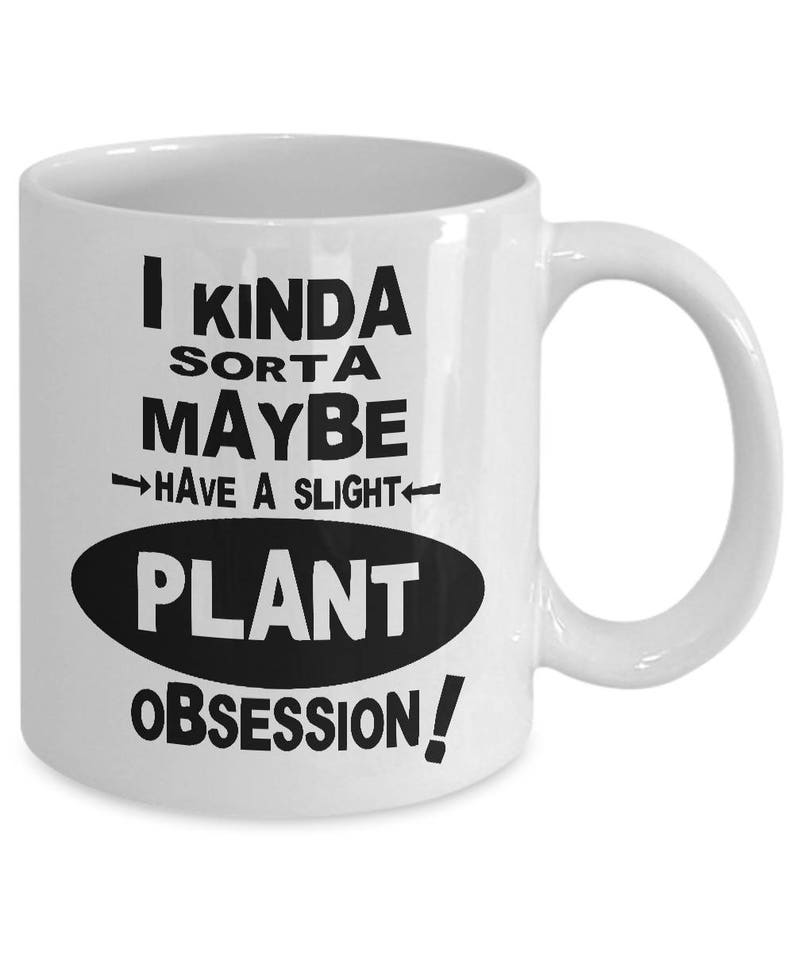 May include: White ceramic mug with a curved handle. The mug features black text that reads "I kinda sorta maybe have a slight plant obsession!" in a playful font. The text is arranged in multiple lines and an oval shape.