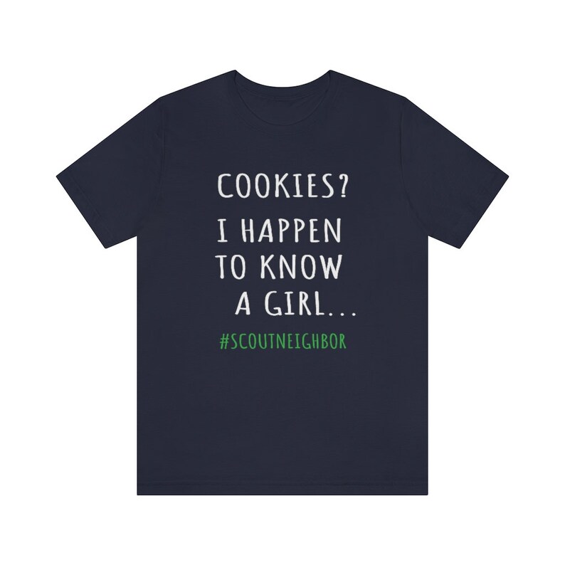 May include: Navy blue t-shirt with white text that reads "COOKIES? I HAPPEN TO KNOW A GIRL... #SCOUTNEIGHBOR".