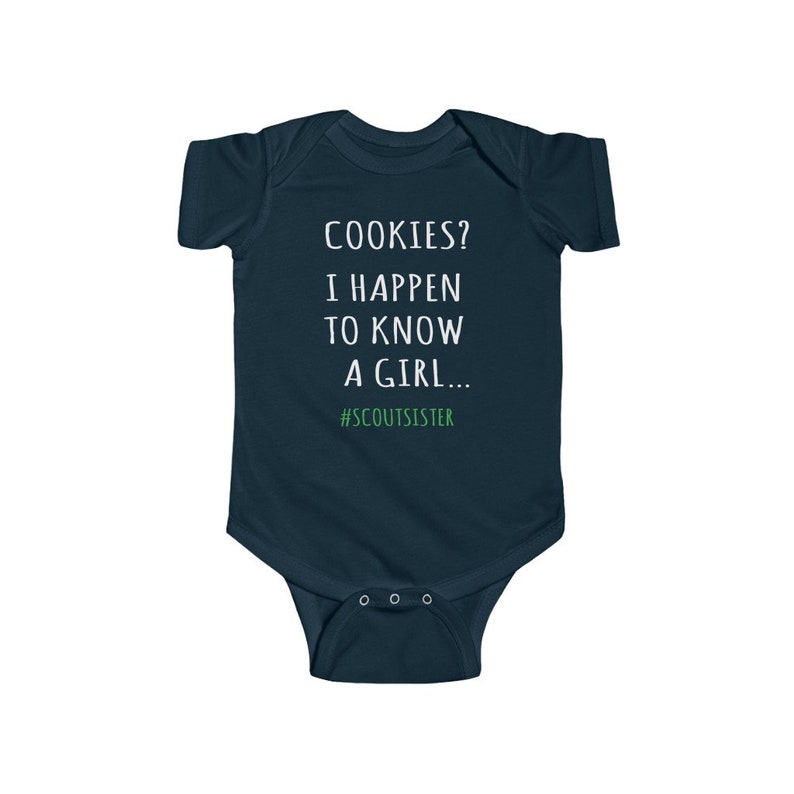 May include: A dark blue baby onesie with white text that reads "COOKIES? I HAPPEN TO KNOW A GIRL... #SCOUTSISTER".