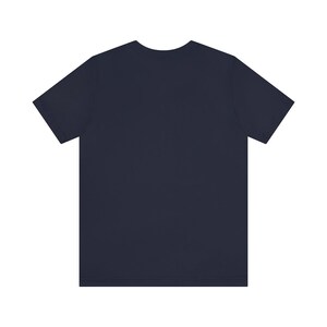 May include: A plain navy blue t-shirt with short sleeves.