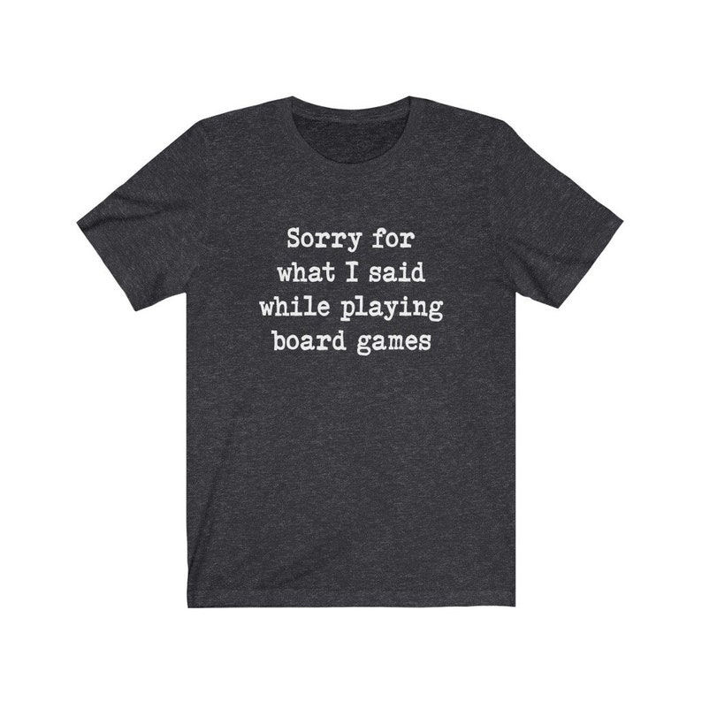May include: Dark heather grey t-shirt with white text that reads "Sorry for what I said while playing board games".