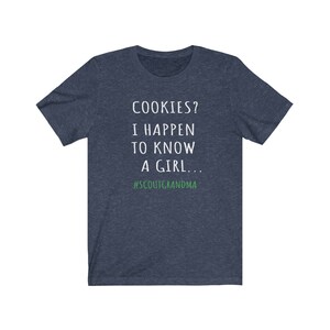 Puede incluir: Una camiseta azul marino con texto blanco que dice "COOKIES? I HAPPEN TO KNOW A GIRL... #SCOUTGRANDMA".