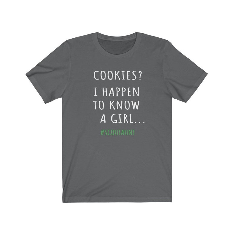 May include: Dark gray t-shirt with white text that reads "COOKIES? I HAPPEN TO KNOW A GIRL... #SCOUTAUNT"